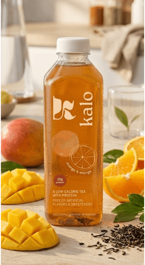 Kalo mango and orange protein tea, styled with fresh mango, orange, and tea leaves